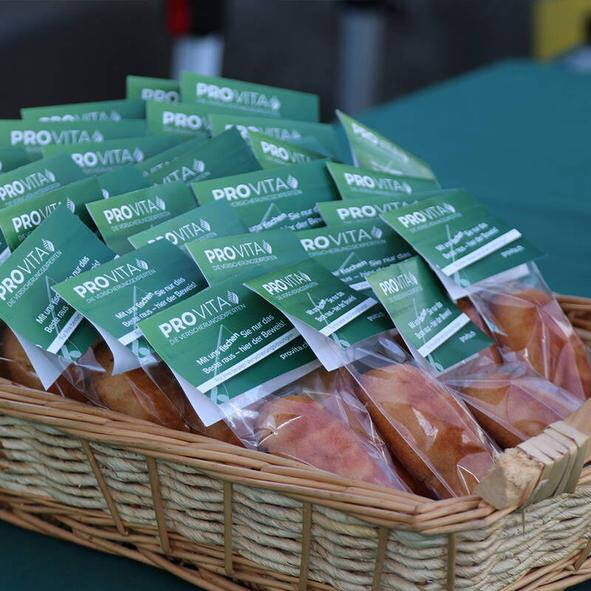 Korb mit verpackten Thunfischli und PRO VITA Branding – kleine Aufmerksamkeit für Marktbesucher.